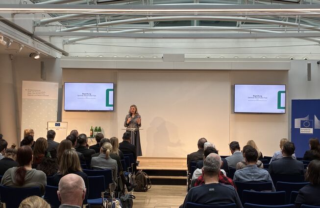 Grafik mit Darstellung KPC-Geschäftsführerin Gerlinde Mayerhofer-Fras bei Eröffnung, mit Link zur Nachlesewebseite